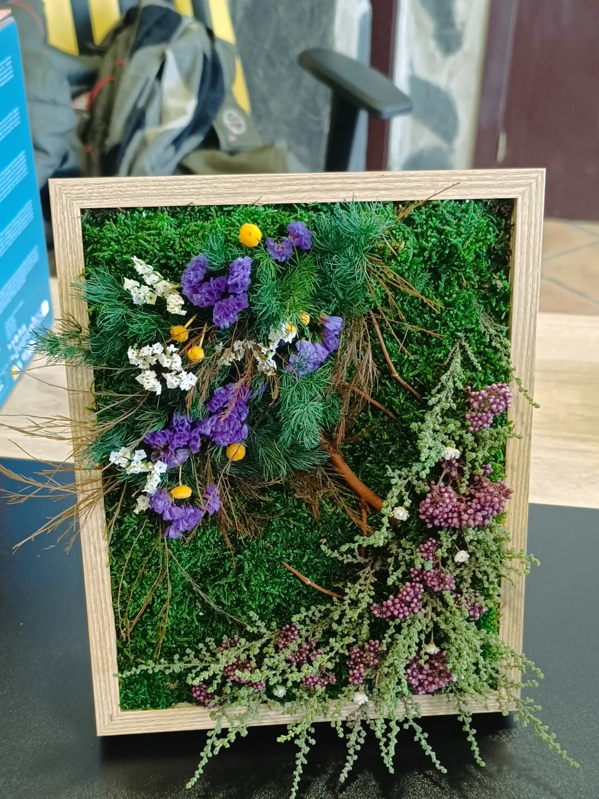 Cuadro de musgo preservado con flores secas moradas