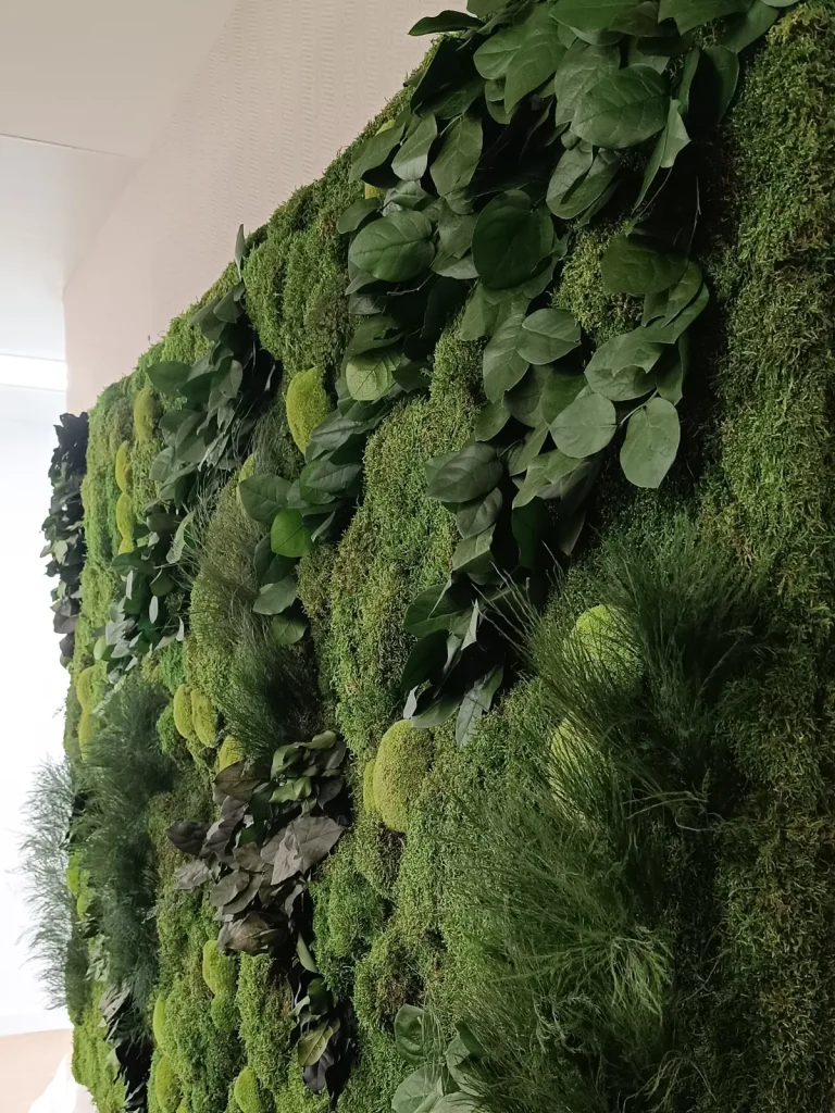 Mural de musgo y plantas preservadas en la pared de una oficina